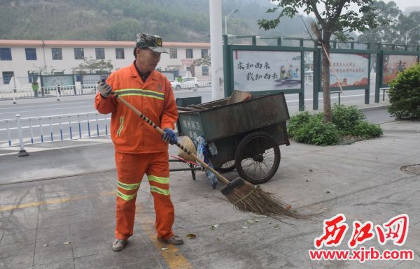 苏仲贤在清扫街面。 西江日报记者 陈松连 摄