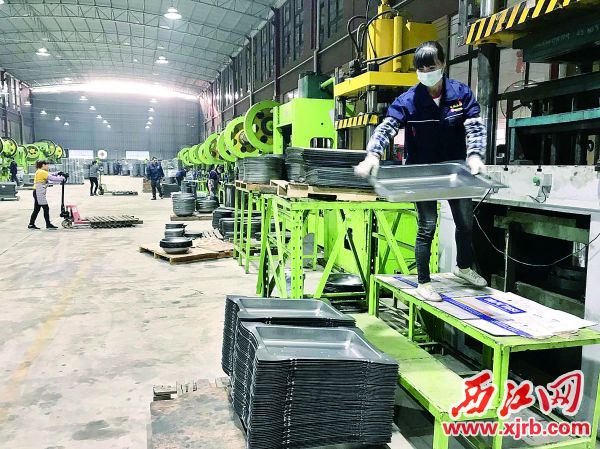 像这样的冲床机，肇庆市铭凯金属制品有限公司有
130台，每台冲床8小时可生产3000个半成品炉体。操作
冲床的工人是入职不久的封开本地人。
