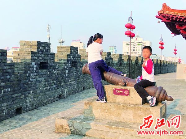 两名孩子在古炮台上攀爬。西江日报记者严炯明 摄
