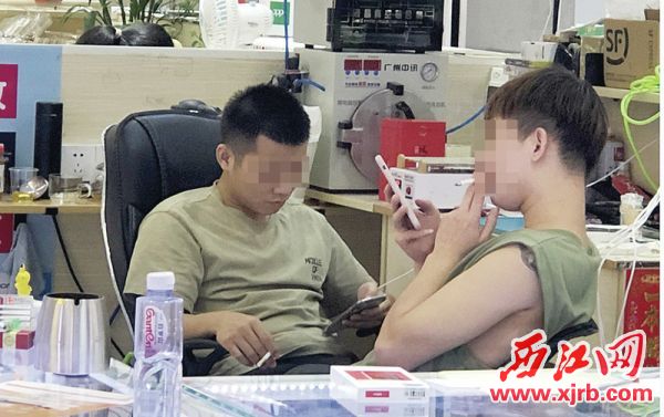 某商场内，两名男子在自顾自抽烟。 西江日报记者 杨乐祺 摄