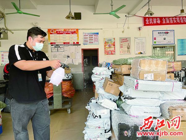 工作人员对到网点的快件进行消毒工作。 西江日报记者 张苑卉 摄