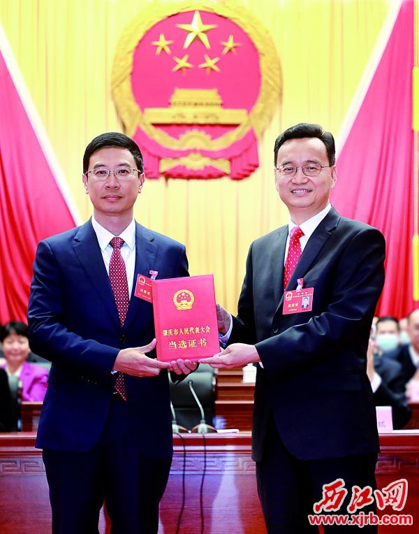 张爱军（右）为许晓雄（左）颁发当选证书。 西江日报记者 刘春林 摄