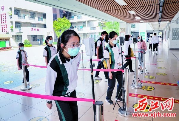 3月15日，在肇庆市颂德学校，学生们戴口罩、有序排队、测量体温做好疫情防控工作。 西江日报记者 梁小明 摄