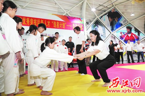 冼東妹（前右）在現場指導學生訓練。 西江日報記者 梁小明 攝