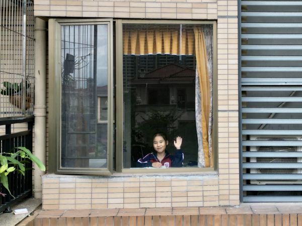 在窗台前学习的小学生，见到无人机，她开心地打了招呼。